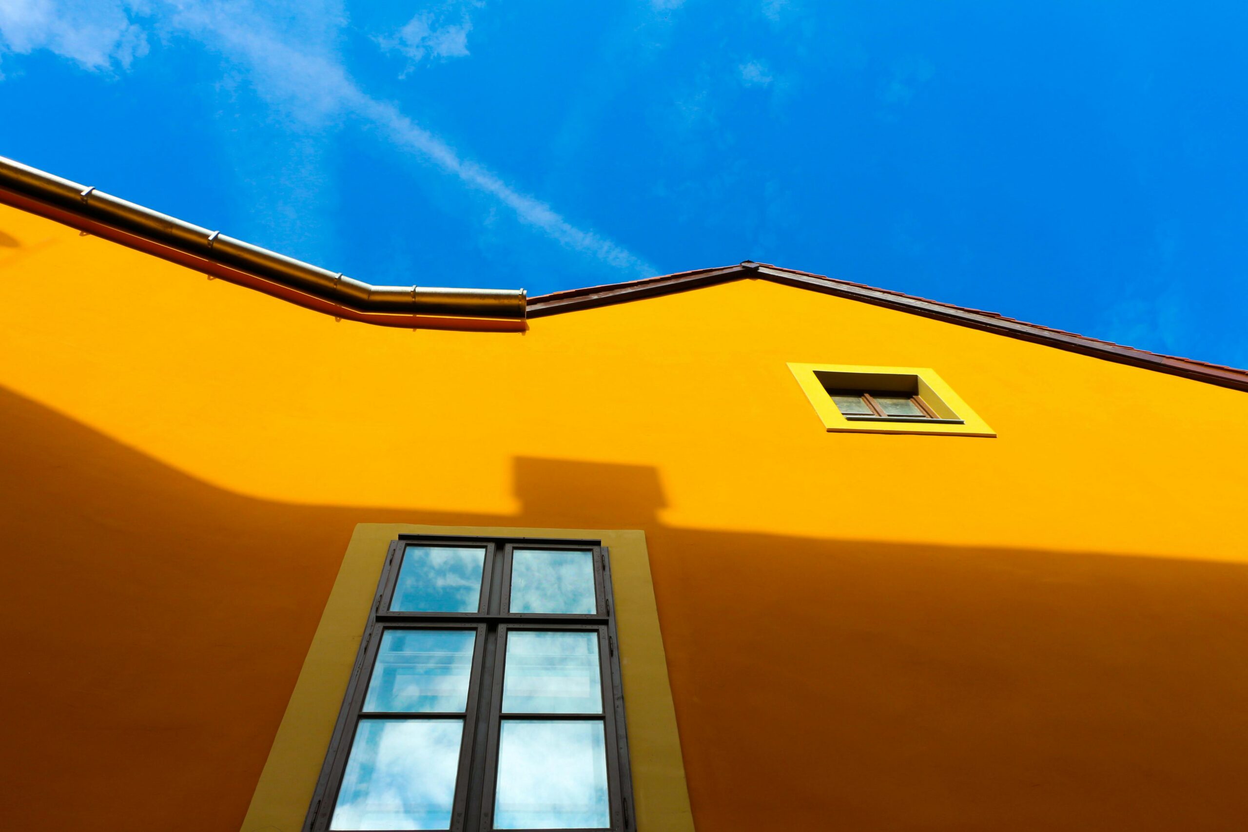 Façade orange lumineuse sous ciel bleu.