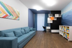 Salon avec canapé bleu et mur assorti.