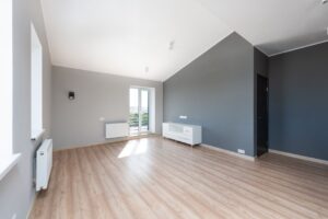 Grande pièce vide aux murs gris et blancs.